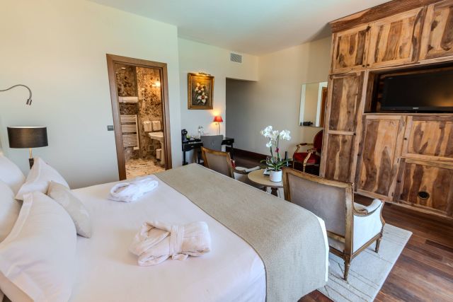 Luxurious hôtel room featuring a bed, elegant décor, and a bathroom visible through a stylish door.