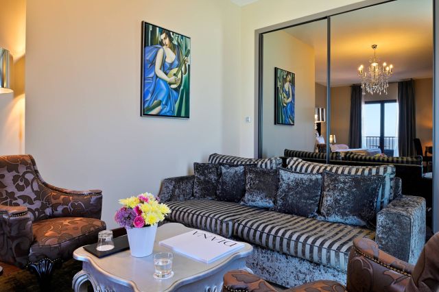 Un salon élégant avec des murs en miroir, des meubles raffinés, des arrangements floraux et des peintures, dég dégagé une sophistication moderne.