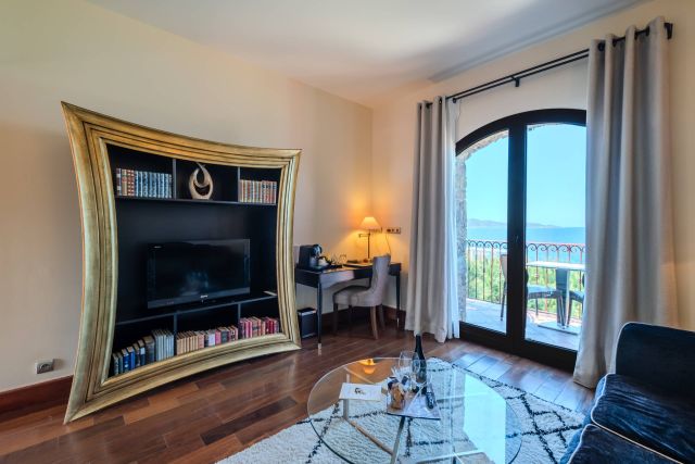 Chambre élégante avec une bibliothèque incurvée unique, un bureau et une vue imprenable à travers la porte du balcon.