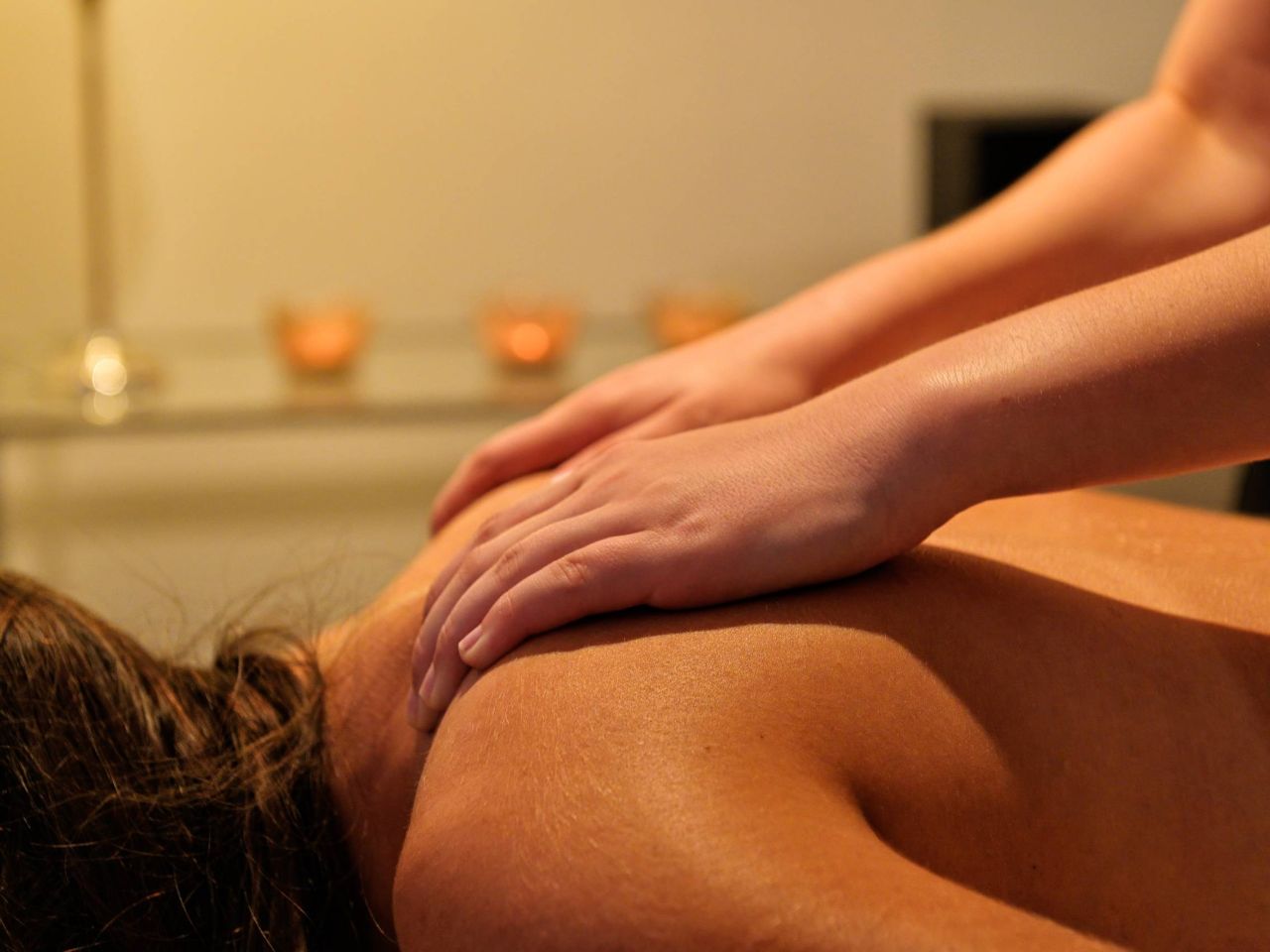 {gpt xx}A pair of hands gently massaging a person's back in a serene, softly lit environment.{gpt}