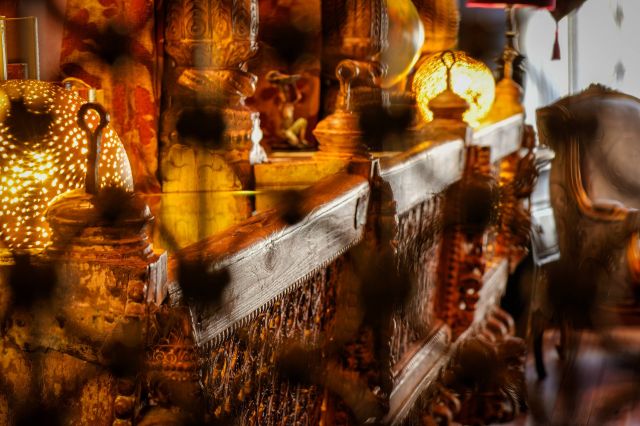 Des meubles en bois décoratifs avec des sculptures élaborées et des lampes lumineuses créent une ambiance chaleureuse et conviviale.